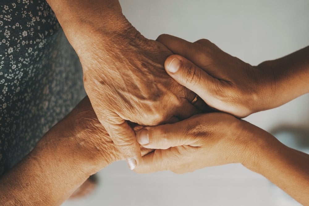 Caring elderly grandma holding hands